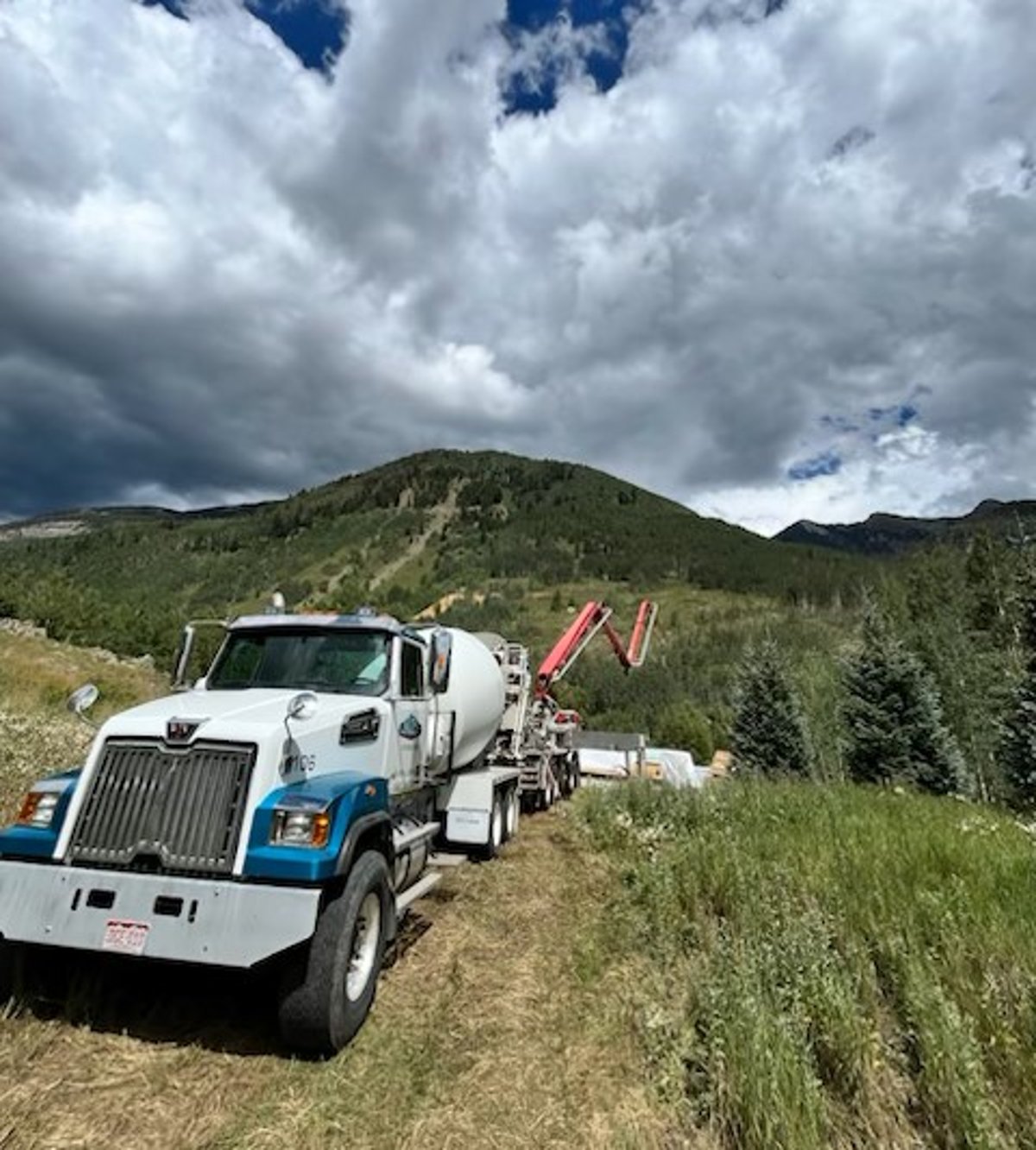 A Smith's Materials mixer truck and concrete pump delivering to a remote mountain job site